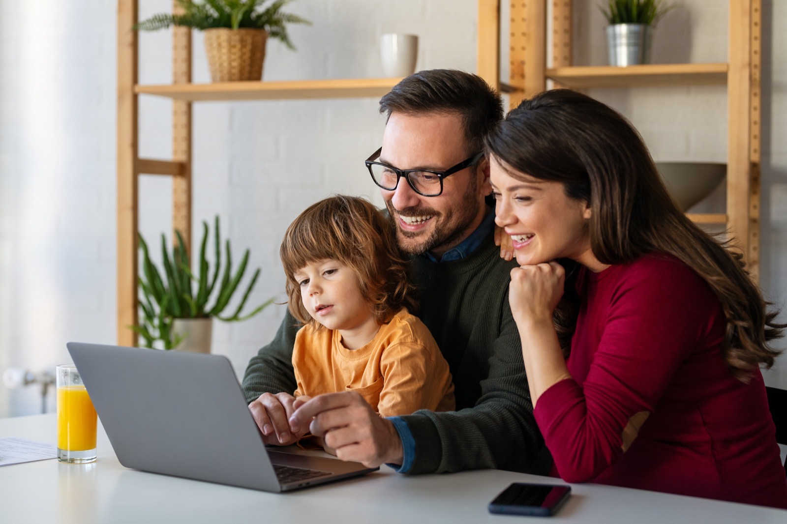 Family looking at laptop together, exploring payment options for eye care
